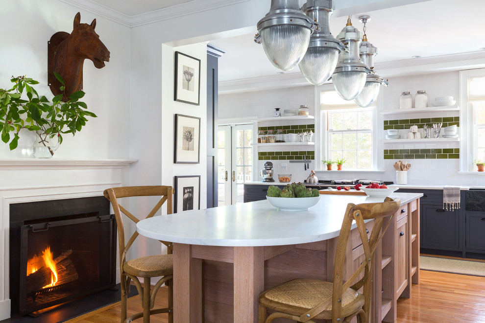 Klassisk inredning av ett avskilt, stort kök, med en rustik diskho, skåp i shakerstil, grå skåp, marmorbänkskiva, vitt stänkskydd, stänkskydd i tunnelbanekakel, svarta vitvaror, mellanmörkt trägolv och en köksö