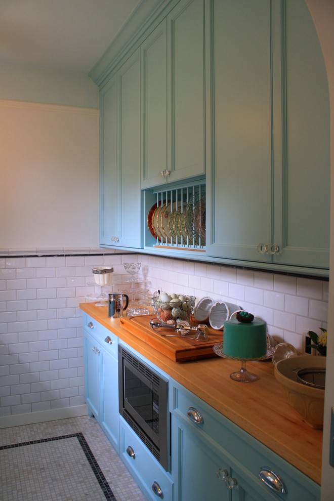 Foto di una cucina tradizionale di medie dimensioni con lavello sottopiano, ante lisce, ante blu, top in quarzo composito, paraspruzzi bianco, paraspruzzi con piastrelle in ceramica, elettrodomestici in acciaio inossidabile e pavimento in marmo