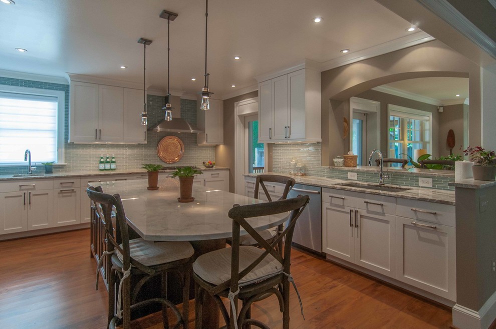 Enclosed kitchen - mid-sized transitional u-shaped medium tone wood floor enclosed kitchen idea in DC Metro with an undermount sink, shaker cabinets, white cabinets, marble countertops, blue backsplash, stainless steel appliances and an island