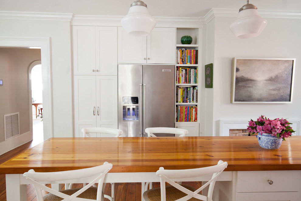 Foto på ett avskilt, mellanstort lantligt u-kök, med en rustik diskho, skåp i shakerstil, vita skåp, marmorbänkskiva, vitt stänkskydd, stänkskydd i keramik, rostfria vitvaror, mellanmörkt trägolv och en köksö