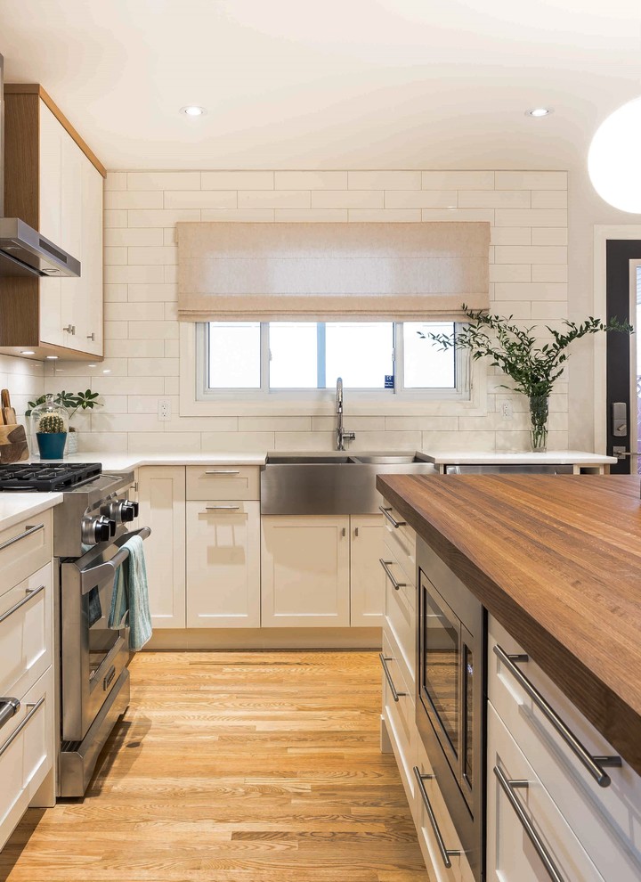 Esempio di una cucina minimalista di medie dimensioni con ante in stile shaker, ante bianche e top in superficie solida