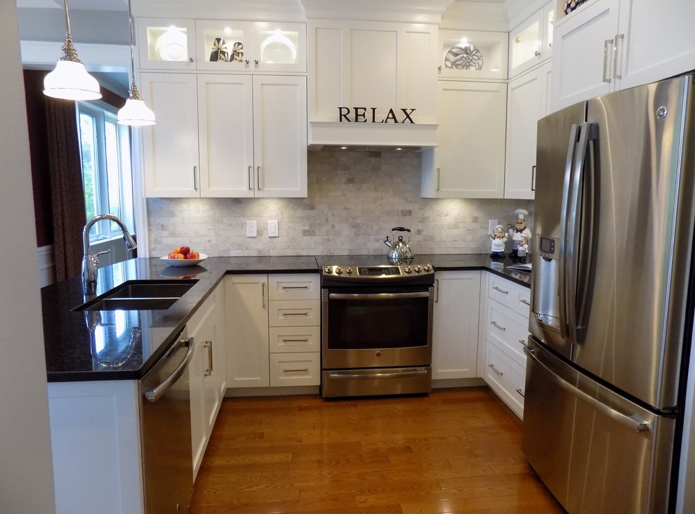 Small transitional u-shaped light wood floor eat-in kitchen photo in Ottawa with an undermount sink, shaker cabinets, white cabinets, granite countertops, gray backsplash, subway tile backsplash, stainless steel appliances and a peninsula