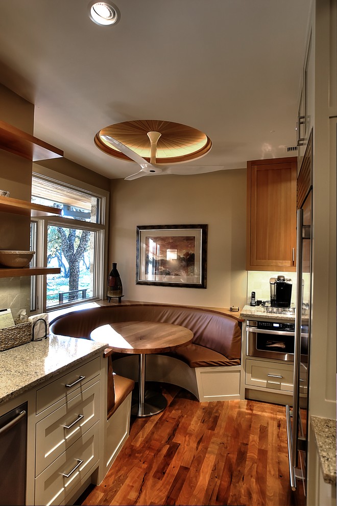 Imagen de cocina actual de tamaño medio con armarios con paneles lisos, puertas de armario de madera clara y electrodomésticos de acero inoxidable