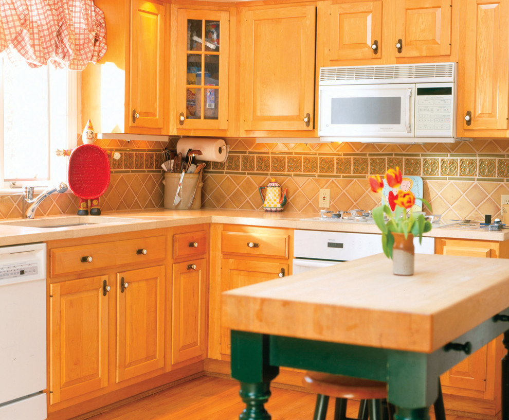 Immagine di una cucina chic con ante con bugna sagomata e paraspruzzi beige