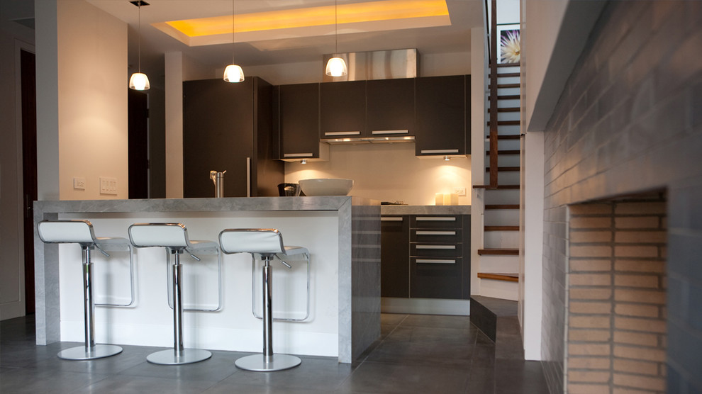 Example of a small minimalist single-wall slate floor eat-in kitchen design in Chicago with flat-panel cabinets, black cabinets and an island