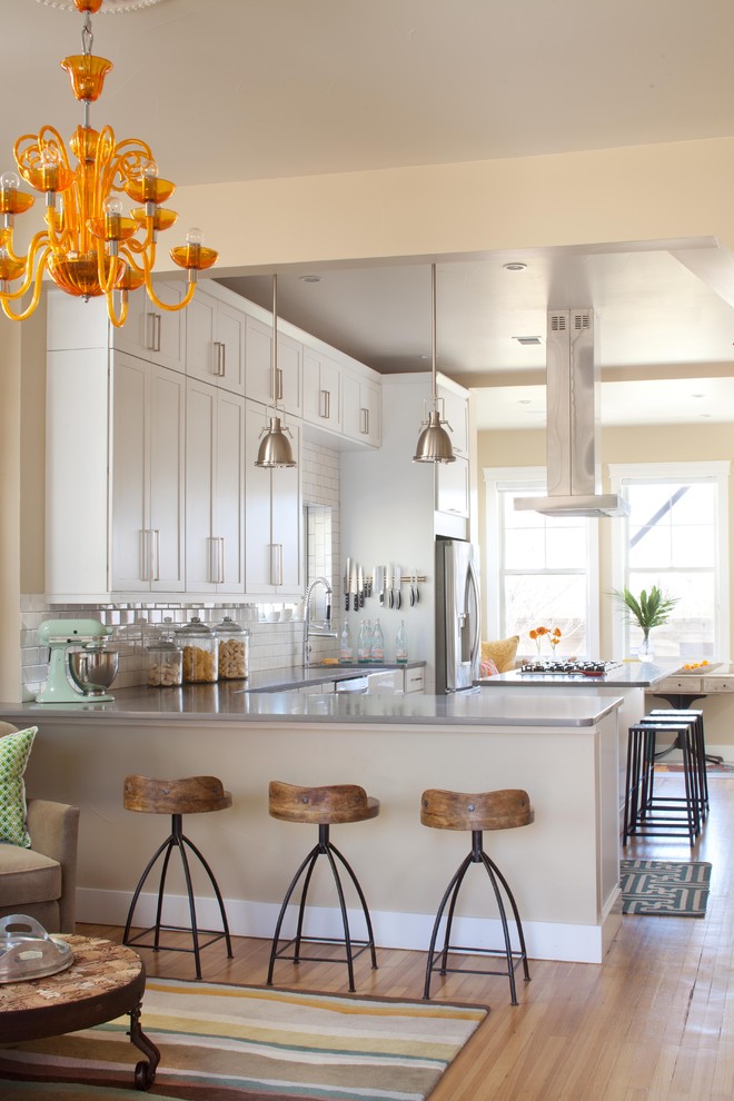 Example of a transitional l-shaped open concept kitchen design in Denver with shaker cabinets, white cabinets, white backsplash, subway tile backsplash and stainless steel appliances