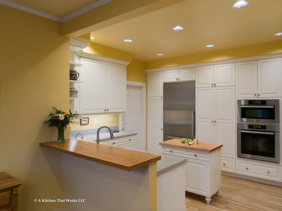 Idéer för att renovera ett stort vintage grå grått kök, med en integrerad diskho, luckor med upphöjd panel, vita skåp, bänkskiva i koppar, rostfria vitvaror, ljust trägolv, en köksö, grått stänkskydd och brunt golv