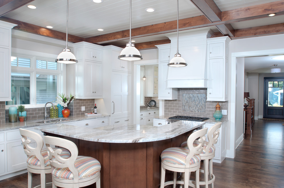 Example of a mid-sized beach style l-shaped medium tone wood floor eat-in kitchen design in Grand Rapids with an undermount sink, recessed-panel cabinets, white cabinets, granite countertops, gray backsplash, subway tile backsplash, stainless steel appliances and an island