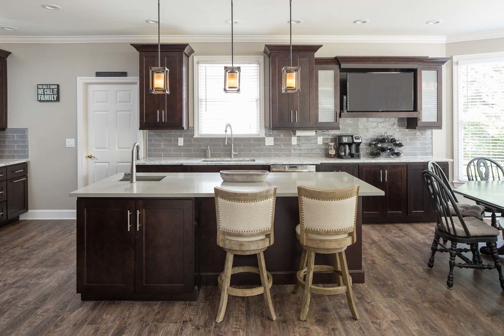 Mid-sized transitional l-shaped laminate floor and brown floor eat-in kitchen photo in Atlanta with an undermount sink, recessed-panel cabinets, dark wood cabinets, quartzite countertops, gray backsplash, ceramic backsplash, stainless steel appliances, an island and white countertops