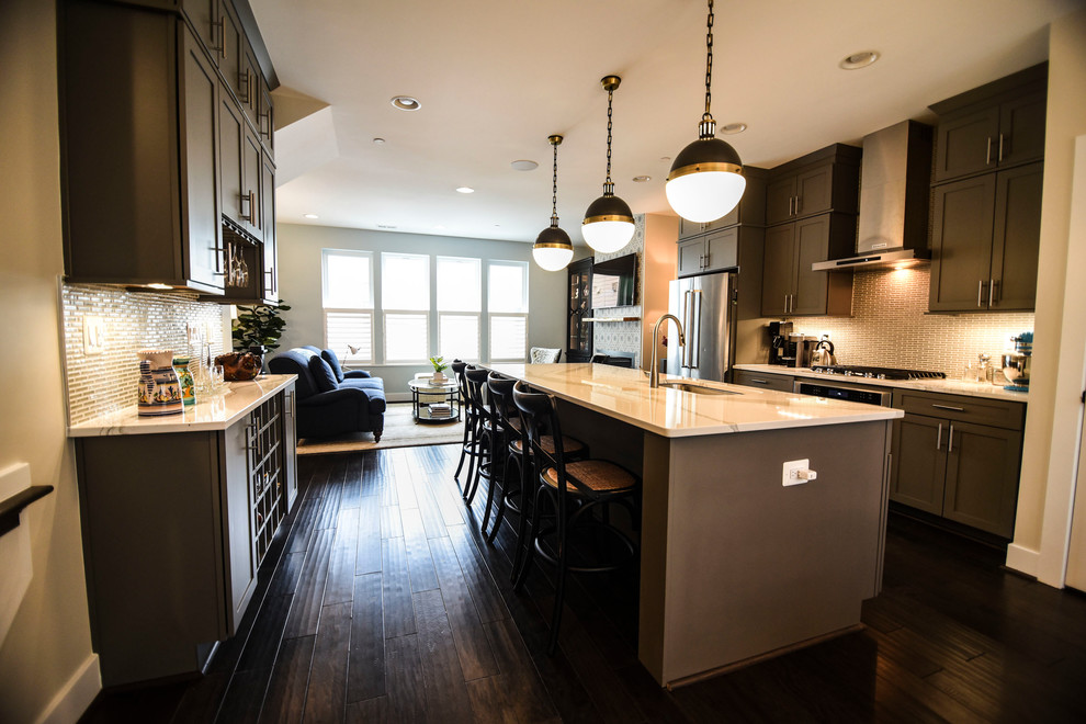 This is an example of a medium sized classic galley open plan kitchen in Baltimore with a submerged sink, shaker cabinets, grey cabinets, engineered stone countertops, grey splashback, porcelain splashback, stainless steel appliances, dark hardwood flooring, an island, brown floors and white worktops.