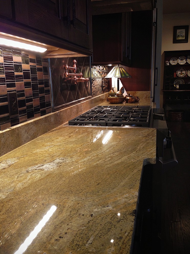 This is an example of a rural galley kitchen/diner in Nashville with a belfast sink, raised-panel cabinets, granite worktops, dark hardwood flooring and an island.