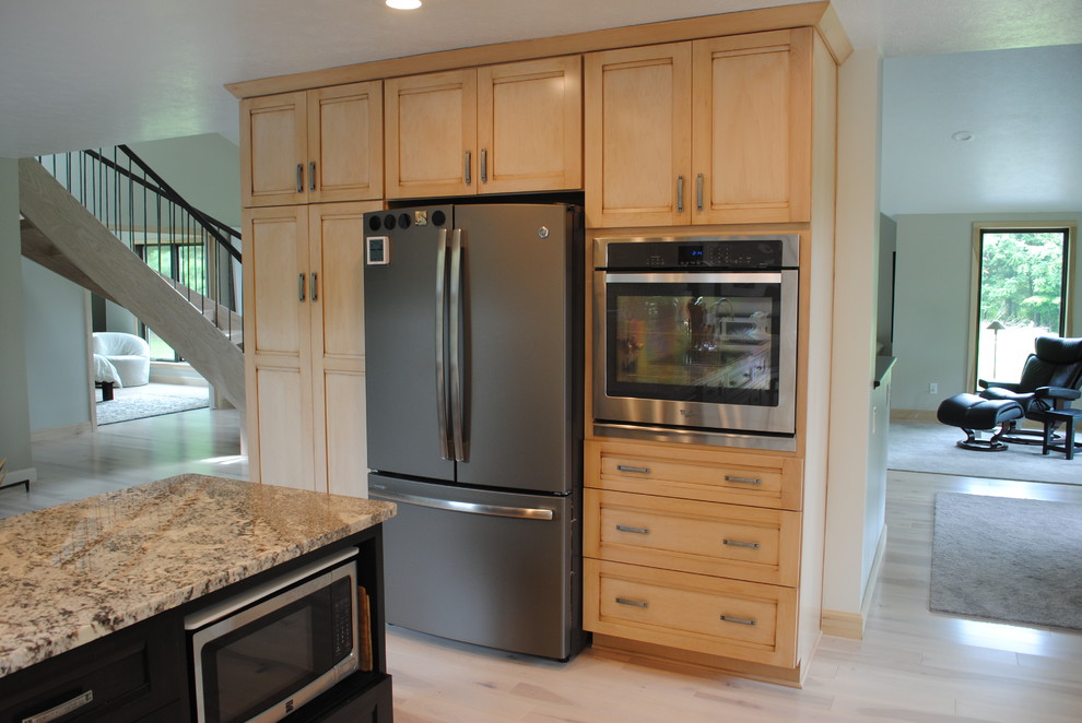 Example of a mid-sized zen single-wall eat-in kitchen design in Cleveland with a single-bowl sink, shaker cabinets, light wood cabinets, granite countertops, white backsplash, subway tile backsplash, stainless steel appliances and an island