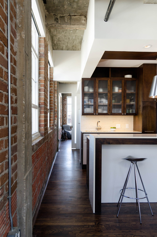 Идея дизайна: кухня в стиле лофт с стеклянными фасадами, темными деревянными фасадами, белым фартуком и барной стойкой