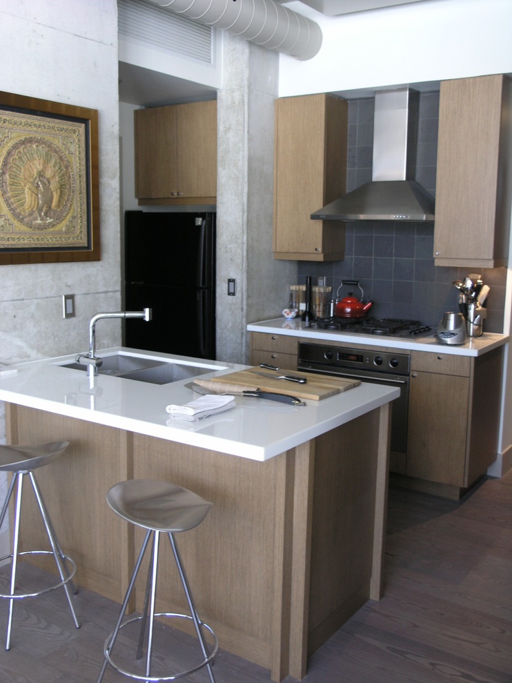 Immagine di una cucina contemporanea con ante lisce, ante in legno chiaro, paraspruzzi grigio e elettrodomestici in acciaio inossidabile