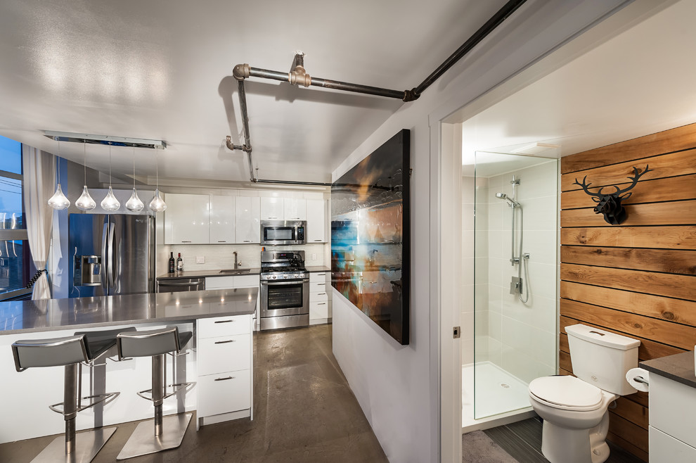Foto de cocina lineal actual con armarios con paneles lisos, electrodomésticos de acero inoxidable y puertas de armario blancas