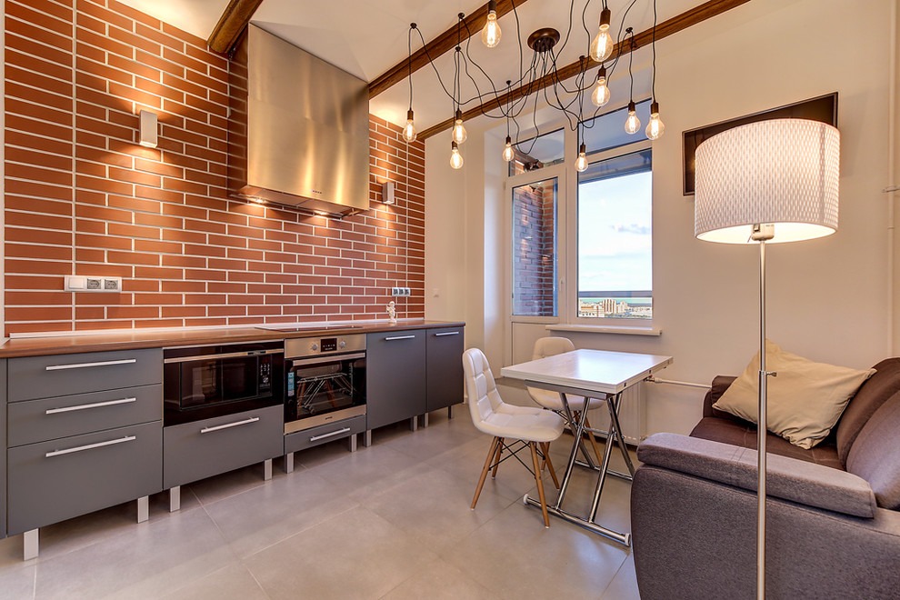 Источник вдохновения для домашнего уюта: кухня в стиле лофт с плоскими фасадами, серыми фасадами, коричневым фартуком и техникой из нержавеющей стали
