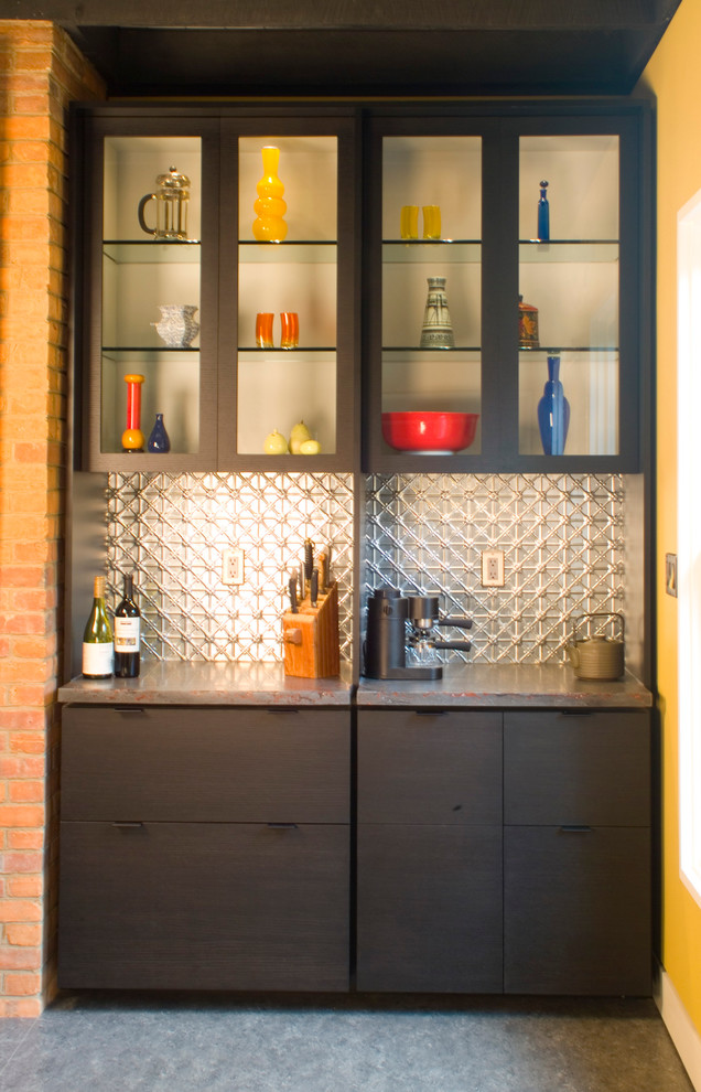 Exemple d'une cuisine américaine avec un placard à porte plane, des portes de placard noires, un plan de travail en béton, une crédence grise, une crédence en dalle métallique et un sol en linoléum.