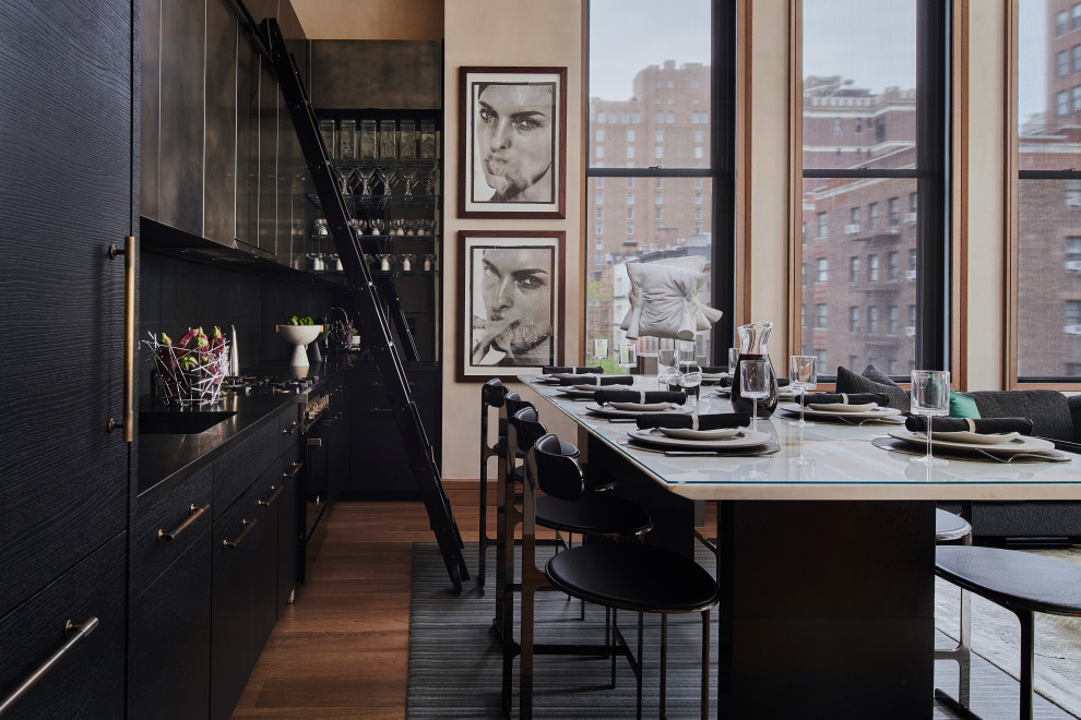 Inspiration for a small contemporary l-shaped kitchen/diner in New York with a submerged sink, flat-panel cabinets, black cabinets, granite worktops, black splashback, limestone splashback, integrated appliances, medium hardwood flooring, no island, beige floors and black worktops.