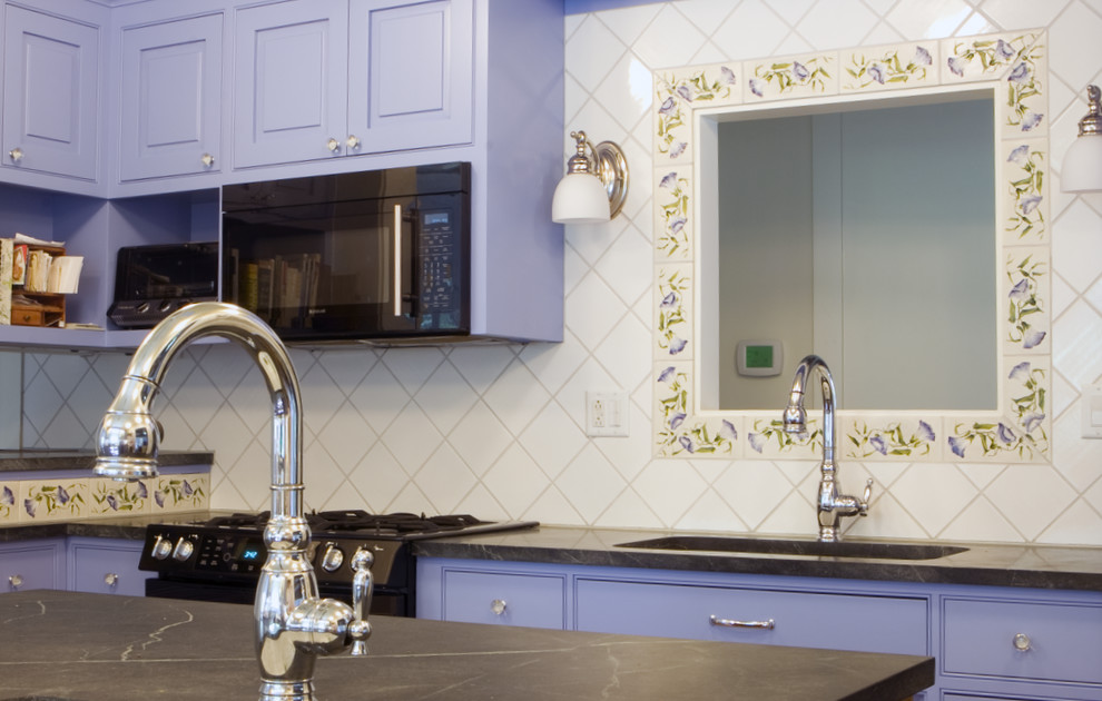 Foto på ett avskilt, mellanstort eklektiskt grå u-kök, med en undermonterad diskho, luckor med upphöjd panel, blå skåp, bänkskiva i täljsten, flerfärgad stänkskydd, stänkskydd i keramik, svarta vitvaror, mellanmörkt trägolv, en köksö och brunt golv