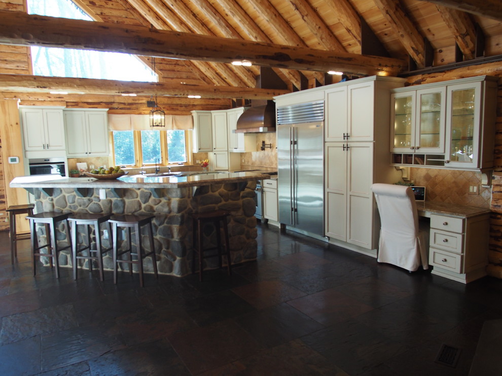 Diseño de cocinas en L rústica grande abierta con fregadero sobremueble, armarios con paneles empotrados, suelo de pizarra y una isla