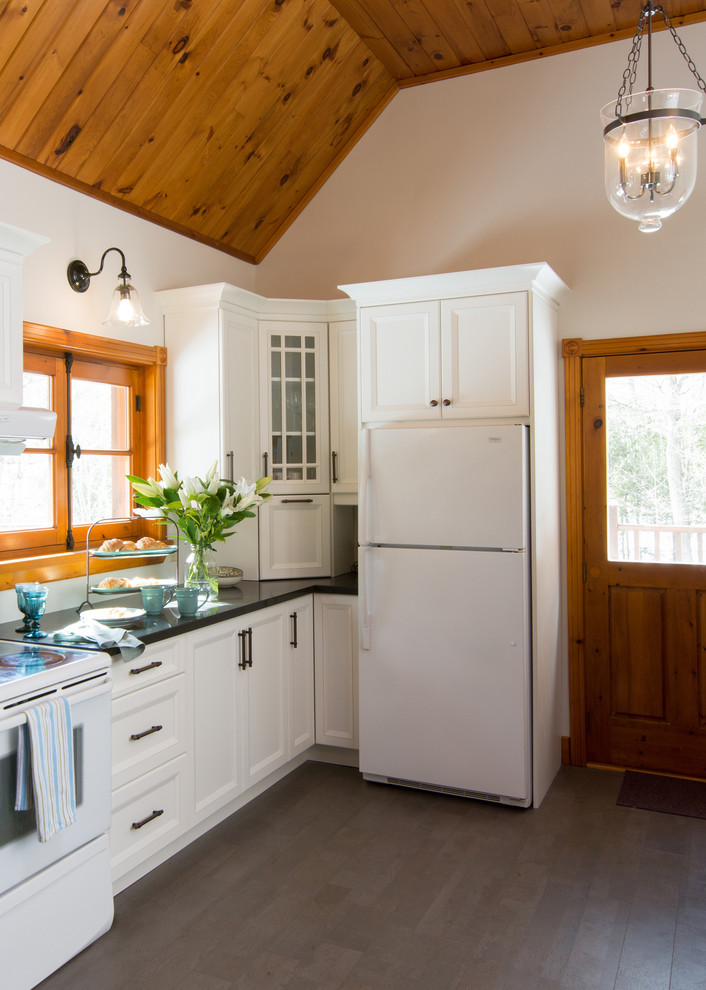 Diseño de cocinas en L rural cerrada con armarios con paneles empotrados, puertas de armario blancas y electrodomésticos blancos