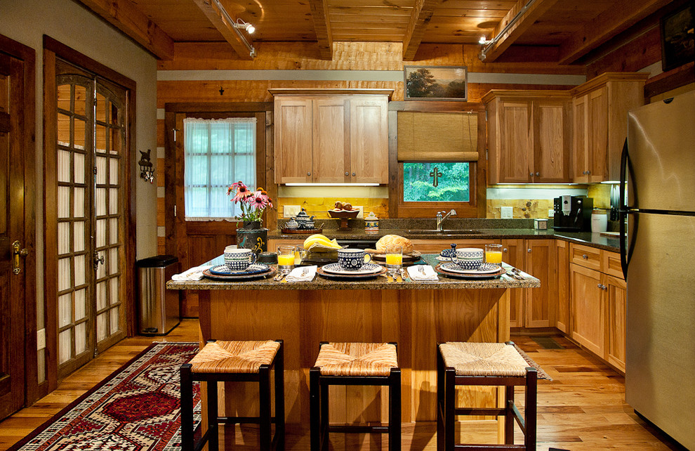 Open concept kitchen - mid-sized rustic l-shaped medium tone wood floor open concept kitchen idea in Nashville with stainless steel appliances, an undermount sink, shaker cabinets, medium tone wood cabinets, granite countertops and brown backsplash