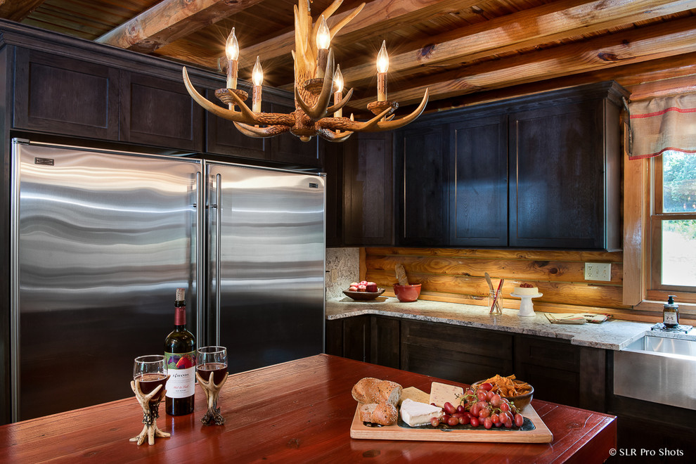 Inspiration for a large rustic u-shaped open plan kitchen in Orlando with a belfast sink, recessed-panel cabinets, black cabinets, granite worktops, brown splashback, stainless steel appliances, dark hardwood flooring and an island.