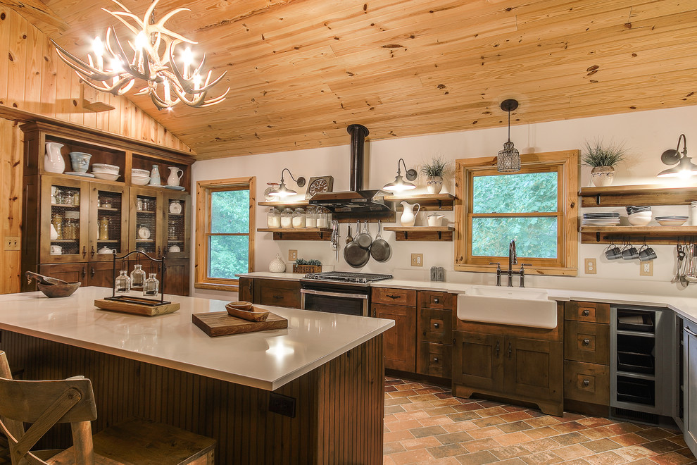 Esempio di una cucina rustica con lavello stile country, ante in stile shaker, ante in legno bruno, elettrodomestici in acciaio inossidabile, pavimento in mattoni e top grigio