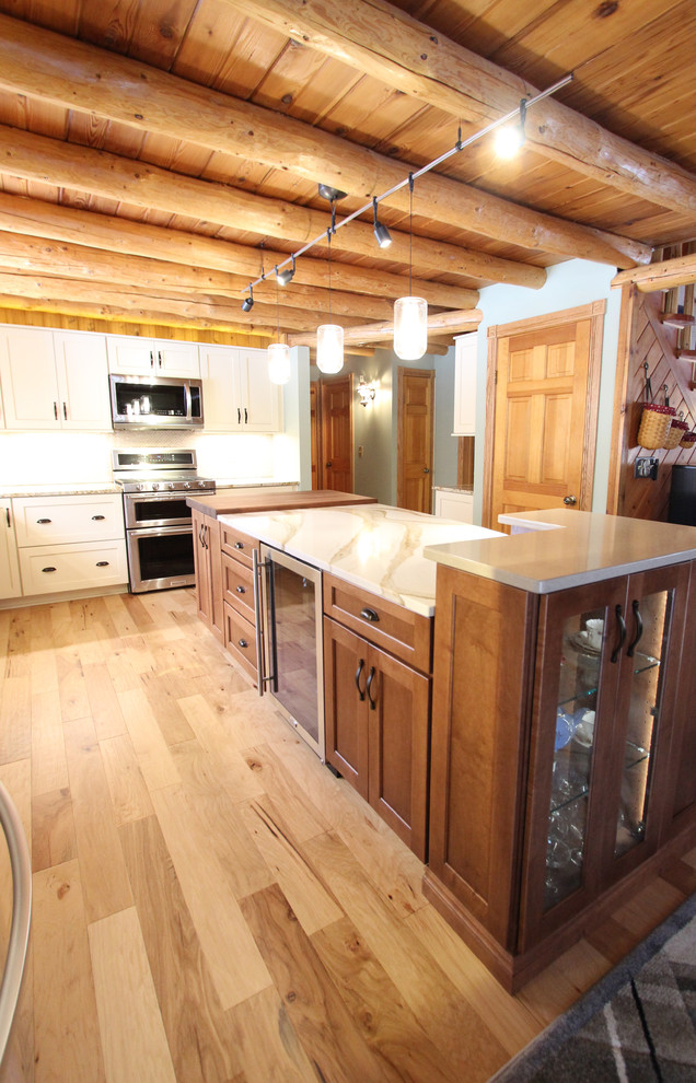 Inspiration for a mid-sized rustic galley eat-in kitchen remodel in Cleveland with a farmhouse sink, recessed-panel cabinets, white cabinets, granite countertops, beige backsplash, mosaic tile backsplash, stainless steel appliances, an island and beige countertops