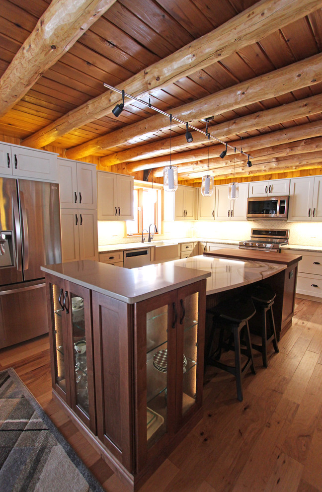 Foto på ett mellanstort rustikt beige kök, med en rustik diskho, luckor med infälld panel, vita skåp, granitbänkskiva, beige stänkskydd, stänkskydd i mosaik, rostfria vitvaror och en köksö