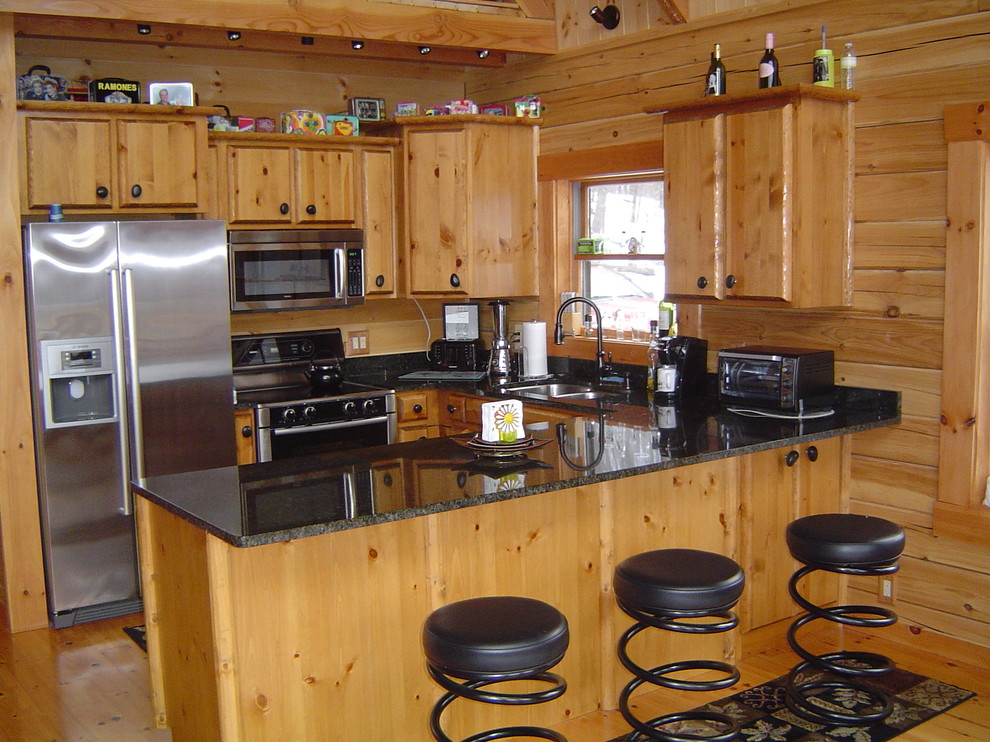 Exemple d'une cuisine américaine montagne en U avec un plan de travail en granite et un électroménager en acier inoxydable.