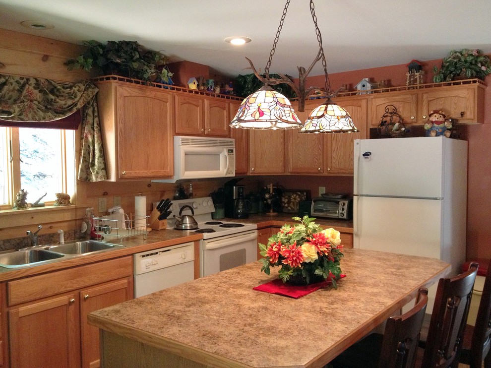 This is an example of a medium sized rural l-shaped kitchen/diner in Other with a double-bowl sink, recessed-panel cabinets, light wood cabinets, white appliances and an island.