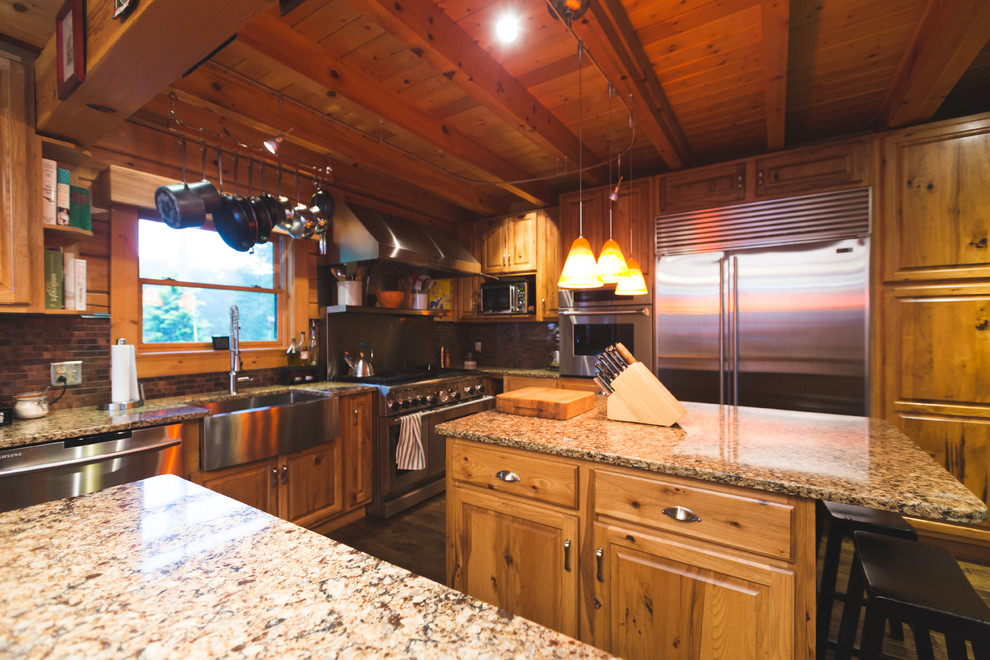 Idéer för ett stort rustikt kök, med en rustik diskho, luckor med upphöjd panel, skåp i mellenmörkt trä, bänkskiva i kvarts, stänkskydd med metallisk yta, stänkskydd i metallkakel, rostfria vitvaror, mellanmörkt trägolv och flera köksöar