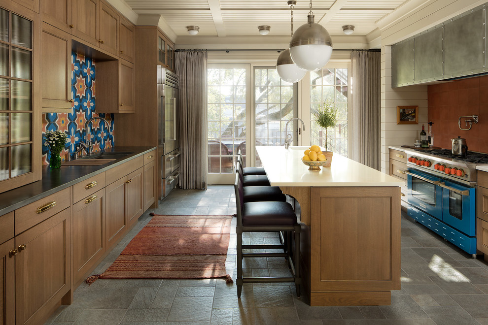 Inspiration for a traditional galley kitchen in Chicago with a submerged sink, recessed-panel cabinets, medium wood cabinets, blue splashback, coloured appliances, an island, grey floors and white worktops.