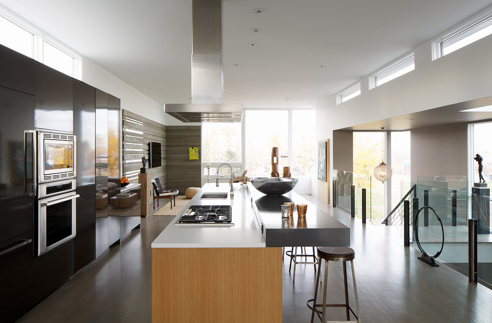 Exemple d'une cuisine ouverte parallèle moderne avec un évier encastré, un placard à porte plane et un électroménager en acier inoxydable.