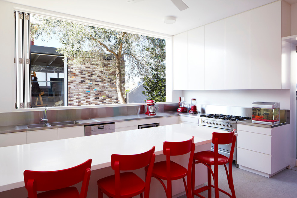 Große Moderne Küche in L-Form mit Doppelwaschbecken, flächenbündigen Schrankfronten, weißen Schränken, Edelstahl-Arbeitsplatte, Küchengeräten aus Edelstahl und Kücheninsel in Sydney