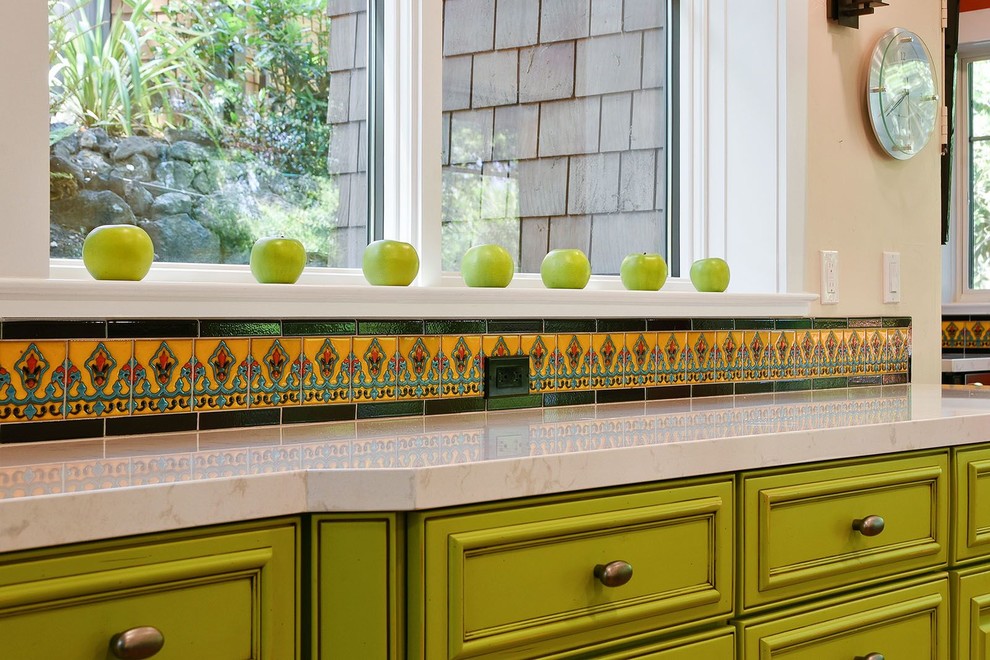 На фото: большая параллельная кухня в классическом стиле с фасадами с выступающей филенкой, зелеными фасадами, столешницей из кварцевого агломерата, разноцветным фартуком и фартуком из керамической плитки
