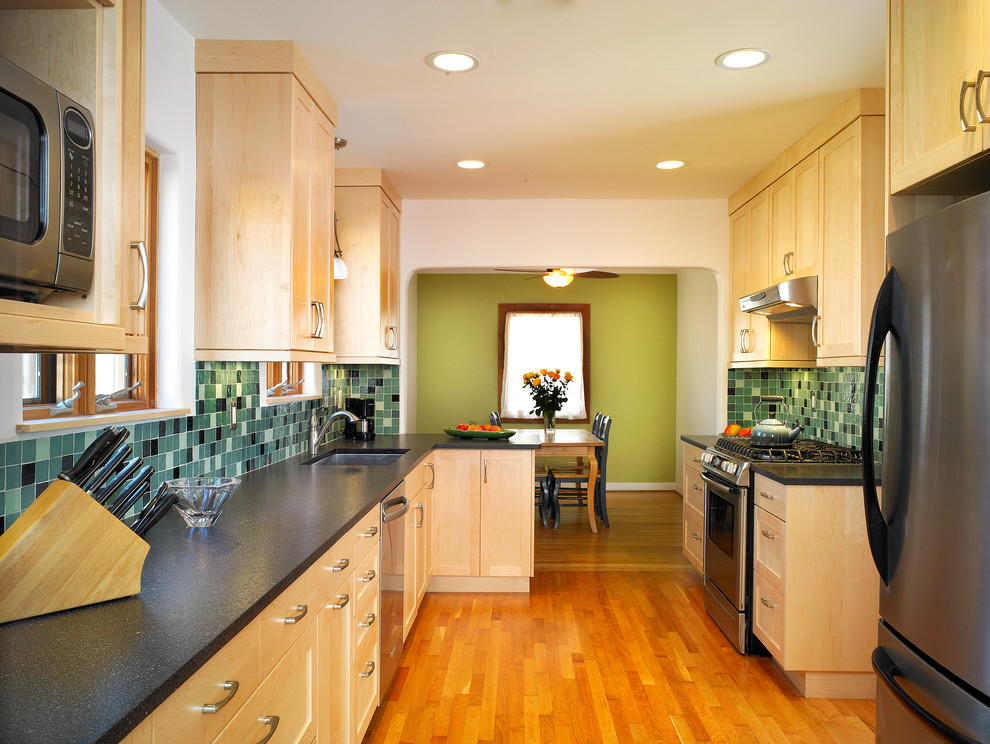 Inredning av ett klassiskt mellanstort kök, med en undermonterad diskho, skåp i shakerstil, skåp i ljust trä, grönt stänkskydd, stänkskydd i keramik, rostfria vitvaror och mellanmörkt trägolv