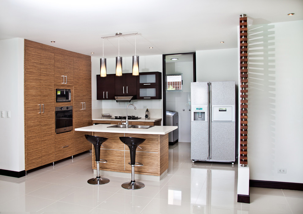 Immagine di una cucina moderna con ante lisce, ante in legno scuro, elettrodomestici in acciaio inossidabile e lavello da incasso