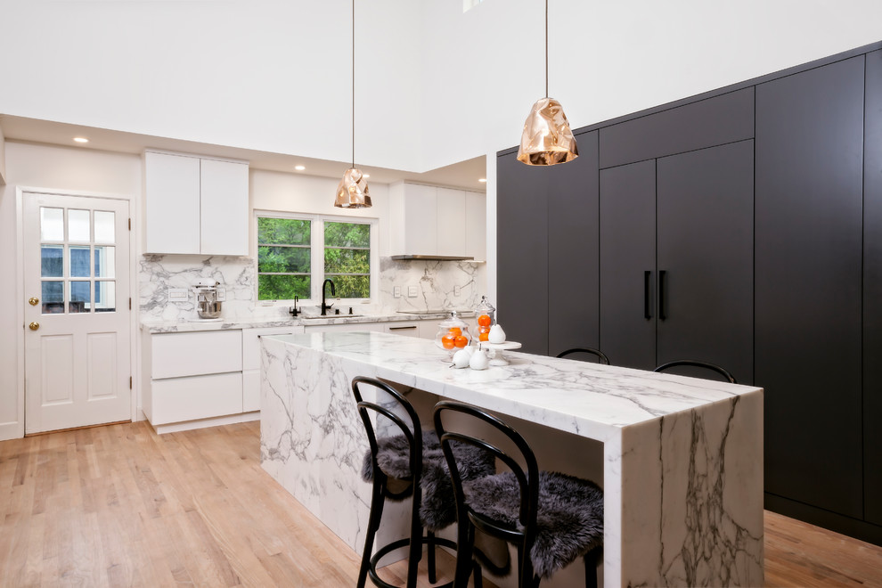 Mid-sized minimalist l-shaped light wood floor and brown floor eat-in kitchen photo in San Francisco with an undermount sink, flat-panel cabinets, gray cabinets, marble countertops, white backsplash, marble backsplash, stainless steel appliances and an island