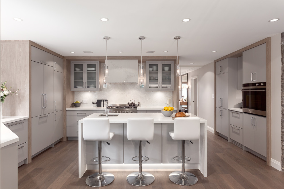 Design ideas for a medium sized contemporary u-shaped kitchen in Vancouver with a submerged sink, flat-panel cabinets, grey cabinets, white splashback, an island, marble worktops, marble splashback, integrated appliances, dark hardwood flooring and brown floors.