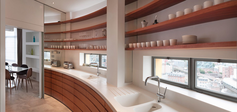 Moderne Küche mit integriertem Waschbecken, hellbraunen Holzschränken, Mineralwerkstoff-Arbeitsplatte, Küchenrückwand in Weiß, Rückwand aus Spiegelfliesen, Küchengeräten aus Edelstahl und Marmorboden in London