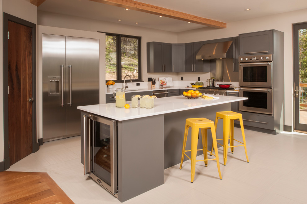 Idéer för ett mellanstort modernt linjärt kök och matrum, med en undermonterad diskho, luckor med infälld panel, grå skåp, bänkskiva i kvarts, gult stänkskydd, rostfria vitvaror, klinkergolv i porslin och en köksö