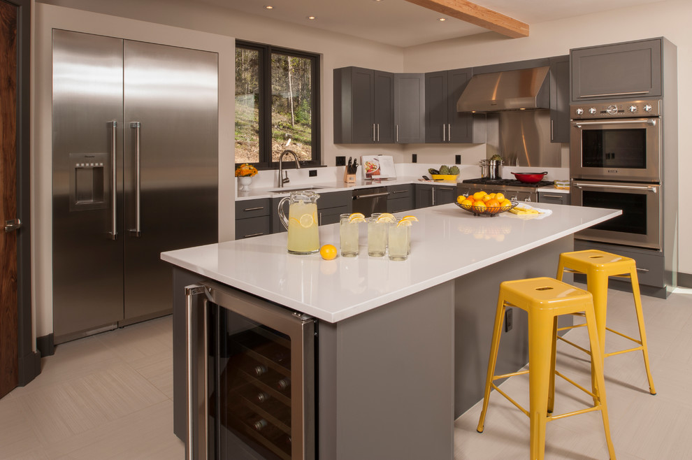 Inspiration for a mid-sized contemporary l-shaped porcelain tile and beige floor eat-in kitchen remodel in Denver with an undermount sink, gray cabinets, quartz countertops, yellow backsplash, stainless steel appliances, an island, shaker cabinets, metal backsplash and white countertops