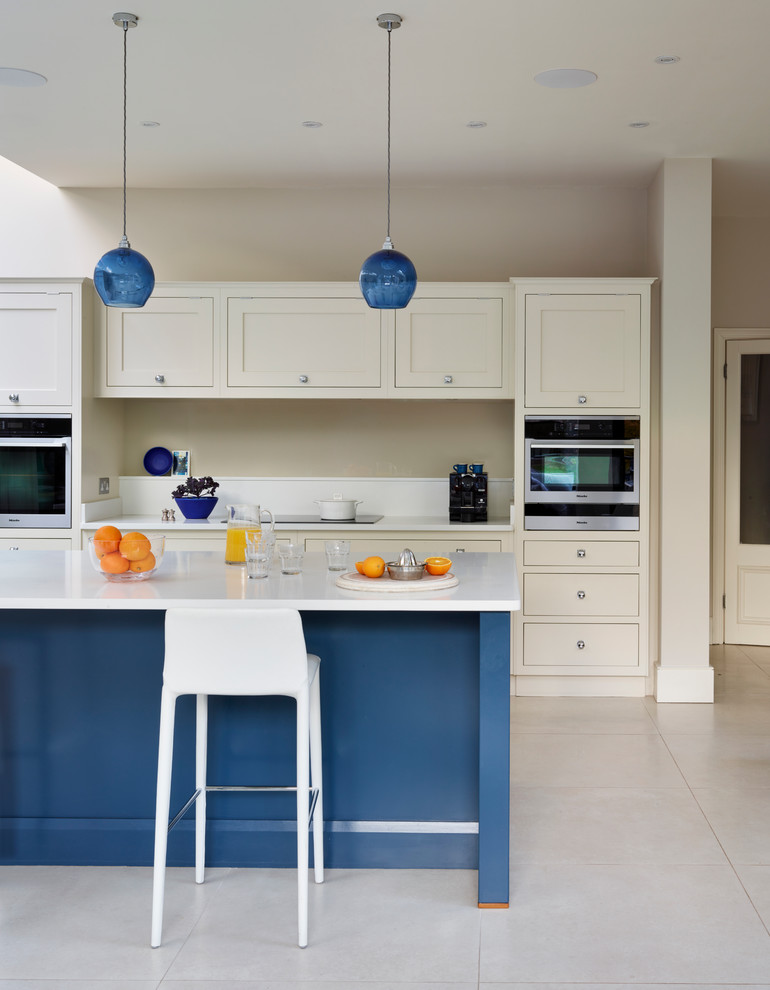 Example of a huge trendy open concept kitchen design in London with shaker cabinets and an island