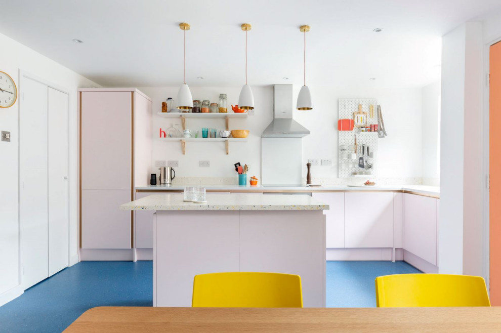 Стильный дизайн: маленькая угловая кухня в современном стиле с обеденным столом, одинарной мойкой, плоскими фасадами, столешницей терраццо, разноцветным фартуком, техникой под мебельный фасад, полом из ламината, островом, синим полом и разноцветной столешницей для на участке и в саду - последний тренд