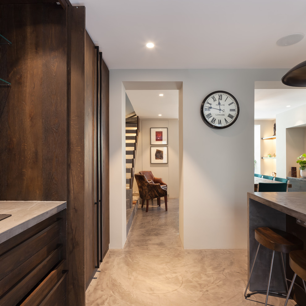 This is an example of a medium sized contemporary open plan kitchen in London with a belfast sink, flat-panel cabinets, dark wood cabinets, concrete worktops, blue splashback, ceramic splashback, stainless steel appliances, concrete flooring, an island and grey floors.