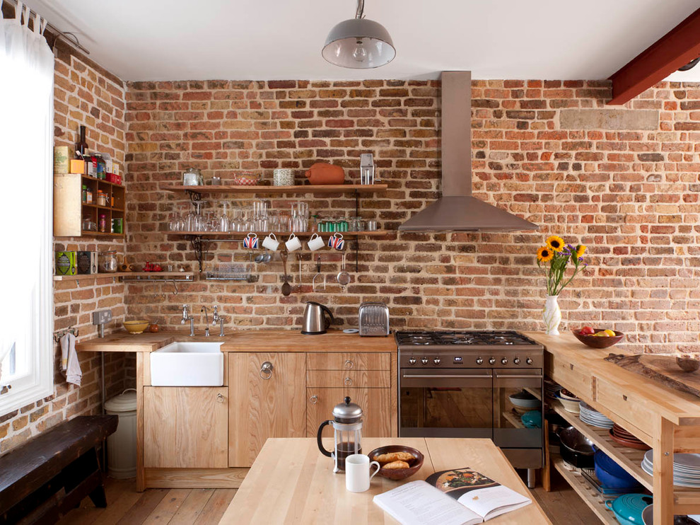 На фото: кухня в современном стиле с деревянной столешницей, с полувстраиваемой мойкой (с передним бортиком), плоскими фасадами и светлыми деревянными фасадами