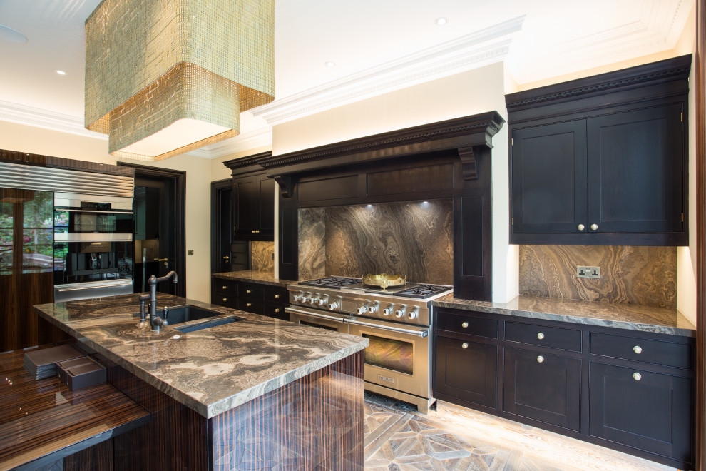 Example of a large transitional l-shaped medium tone wood floor and brown floor eat-in kitchen design in London with an undermount sink, marble countertops, brown backsplash, marble backsplash, stainless steel appliances, an island, brown countertops, shaker cabinets and black cabinets