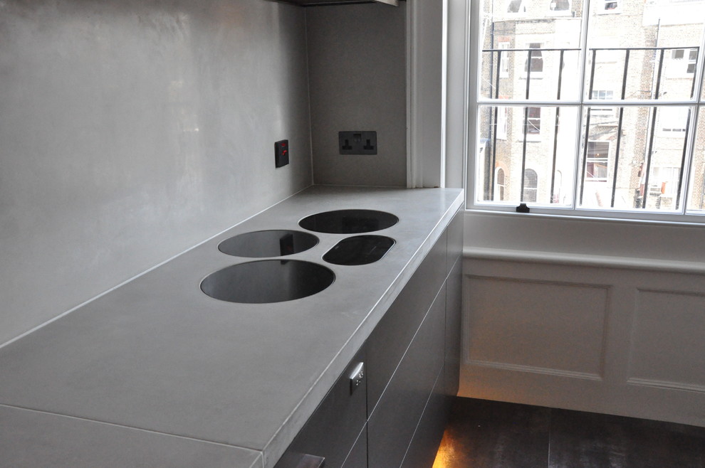 This is an example of a modern galley open plan kitchen in London with flat-panel cabinets.